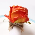 Detail of a handmade orange rose napkin ring with wooden loop on a white plate - Orange Red (Style 6)