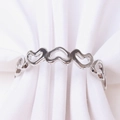 Detail view of silver hollow heart napkin ring with multiple interlocking heart designs - Silver