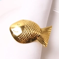 Détail d'un rond de serviette en forme de poisson doré poli sur un tissu blanc - Doré