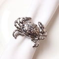 Elegant silver crab napkin ring with detailed texture on a white cloth napkin - Silver