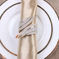 Elegant wing-shaped gold napkin ring with silver glitter finish on a white dinner plate - Wing Shape Gold Base Silver Frosted (ZWZ-RNP-032)