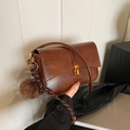 Vintage brown leather shoulder bag with gold buckle and plush ball charm detail - With Pendant / Brown PU Leather