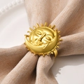 Golden sun and moon napkin ring on a beige linen napkin with white ceramic plate - Gold