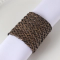 Handcrafted dark brown woven leather napkin ring shown on white fabric napkin - Vintage Rattan Style / Brown