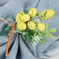 Detail of Easter napkin ring with yellow speckled eggs, artificial flowers and silk ribbons - Yellow