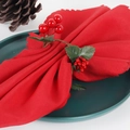 Christmas napkin ring with red berries and green leaves on a dark green dinner plate - Christmas Red Berry Napkin Ring