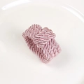 Détail d'un rond de serviette tressé en satin rose avec une finition soyeuse et brillante - Rose