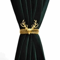 Golden deer head curtain tieback with flexible metal spring on a dark green velvet drape - Deer Head Curtain Tieback