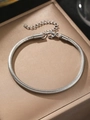 Detail van zilveren slangenschakelarmband met karabijnsluiting op zijden dienblad - Zilver (N9140)