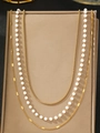 Detail of layered gold metal chain and white pearl strand on a brown jewelry display - Gold Multi-layer Pearl Style (C6821)
