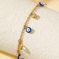 Goldenes Fußkettchen mit blauem Evil-Eye-Anhänger und Kristallsteinen auf weißem Podest - Gold (C6593)