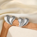 Polished silver heart stud earrings with fluid design on a beige display stand - Silver Style (C5442)