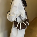 Brown suede crescent bag with white faux fur trim shown on a model for winter style - Coffee