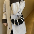 Black croissant bag with white faux fur stripes shown in a stylish crossbody style - Black