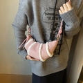 Pink crescent horn crossbody bag with white plush trim and suede finish on model - Pink