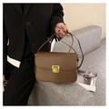 Coffee brown leather rectangular crossbody bag with gold buckle held by a model - Dark Brown