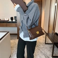 Minimalist brown leather square tote bag with gold metal buckle shown in a lifestyle setting - Coffee