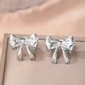 Boucles d'oreilles nœud en argent poli sur un plateau à bijoux avec éclairage élégant - Style Nœud Argenté (C9290)