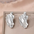 Poliierte Edelstahl-Ohrstecker mit Lavatextur auf einer Schmuckschatulle - Silber (F892)