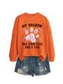Détail du sweat orange avec motif patte fleurie et texte My Shadow Has Four Legs - Orange (Lettres Noires)