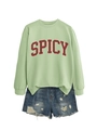 Detail of light green sweatshirt with red SPICY print and distressed denim shorts - Olive Green