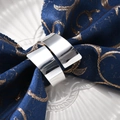 Polished silver napkin ring on blue embroidered fabric for elegant table setting - Silver Polished Blade Napkin Ring / Silver