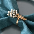 Portatovagliolo dorato con fiori di perle e strass su un tovagliolo blu scuro - Perla Strass Oro Rosa