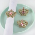 Macro shot of crown napkin rings with pink and green crystals on mint green plate - Rhinestone Crown Style