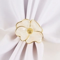 Detailed macro view of white enamel flower napkin ring with elegant gold plating - White Enamel Flower