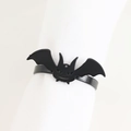 Close-up of a polished black bat napkin ring on a white display for Halloween table decor - Bat Style