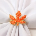Detail eines Metall-Ahornblatt-Serviettenrings mit orangefarbenem Emaille-Finish - Orange