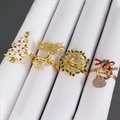 Details von Weihnachts-Serviettenringen mit Hirsch- und Baum-Motiven aus Emaille - 4er-Set Weihnachts-Kombination