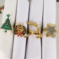 Detail of four festive napkin rings featuring Christmas tree, deer, wreath and snowflake designs - Christmas Tree Wreath Reindeer And Snowflake Style (Set 13)