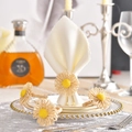 Close-up of handmade straw daisy napkin rings on white fabric with elegant tableware - Beige Handmade Straw Flower