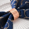 Rose gold woven metal napkin ring on navy blue linen napkin and white ceramic plate - Rose Gold