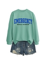 Detail of mint green sweatshirt with Emergency Medical Technician print and denim shorts - Light Green Sweatshirt (Black Text)