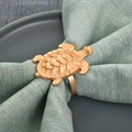 Rond de serviette tortue dorée avec texture en relief sur tissu vert et assiette sombre - Rond de serviette tortue / Doré