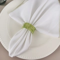 Translucent green resin napkin ring with gold foil flakes on a white linen napkin - Green