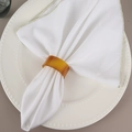 Minimalist amber resin napkin ring on a white napkin and ceramic plate for dining - Amber