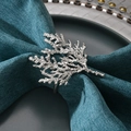 Detail of silver coral-shaped alloy napkin ring on a textured teal cloth napkin - Silver Cypress Branch