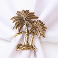 Detailed view of vintage gold palm tree napkin rings on elegant white fabric napkins - Retro Coconut Tree / Antique Gold
