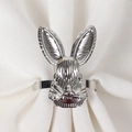 Close-up of a silver rabbit head napkin ring on a textured white fabric napkin - Silver