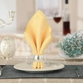 Close-up of a silver waved textured metal napkin ring on a yellow scalloped napkin - Silver