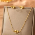 Elegant gold knot jewelry set with necklace and stud earrings on silk background - Knot Design Set / Gold (F157)
