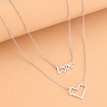 Zweilagige silberne Halskette mit Love-Schriftzug und Pixel-Herzanhänger auf rosa Hintergrund - Silber Pixel Herz & Love Doppelreihiger Stil (B4338)