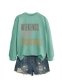 Detail of mint green sweatshirt with 'Weekends Coffee' print and distressed denim shorts - Light Green