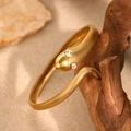 Golden snake-shaped bangle with scale texture and crystals on a natural wood display - Gold (F3029)