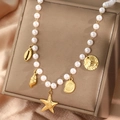 Elegante Perlenkette mit goldenen Seestern- und Muschelanhängern auf Lederständer - Gold (F969)