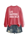 Detail eines roten Sweatshirts mit 'LIFE HAPPENS. DOGS HELP.' Aufdruck und zerrissenen Denim-Shorts - S / Rot (Weiße Schrift)