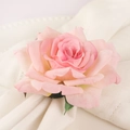Pink fabric rose napkin ring with green leaves on white textured dinner plate - Artificial Pink Rose Style